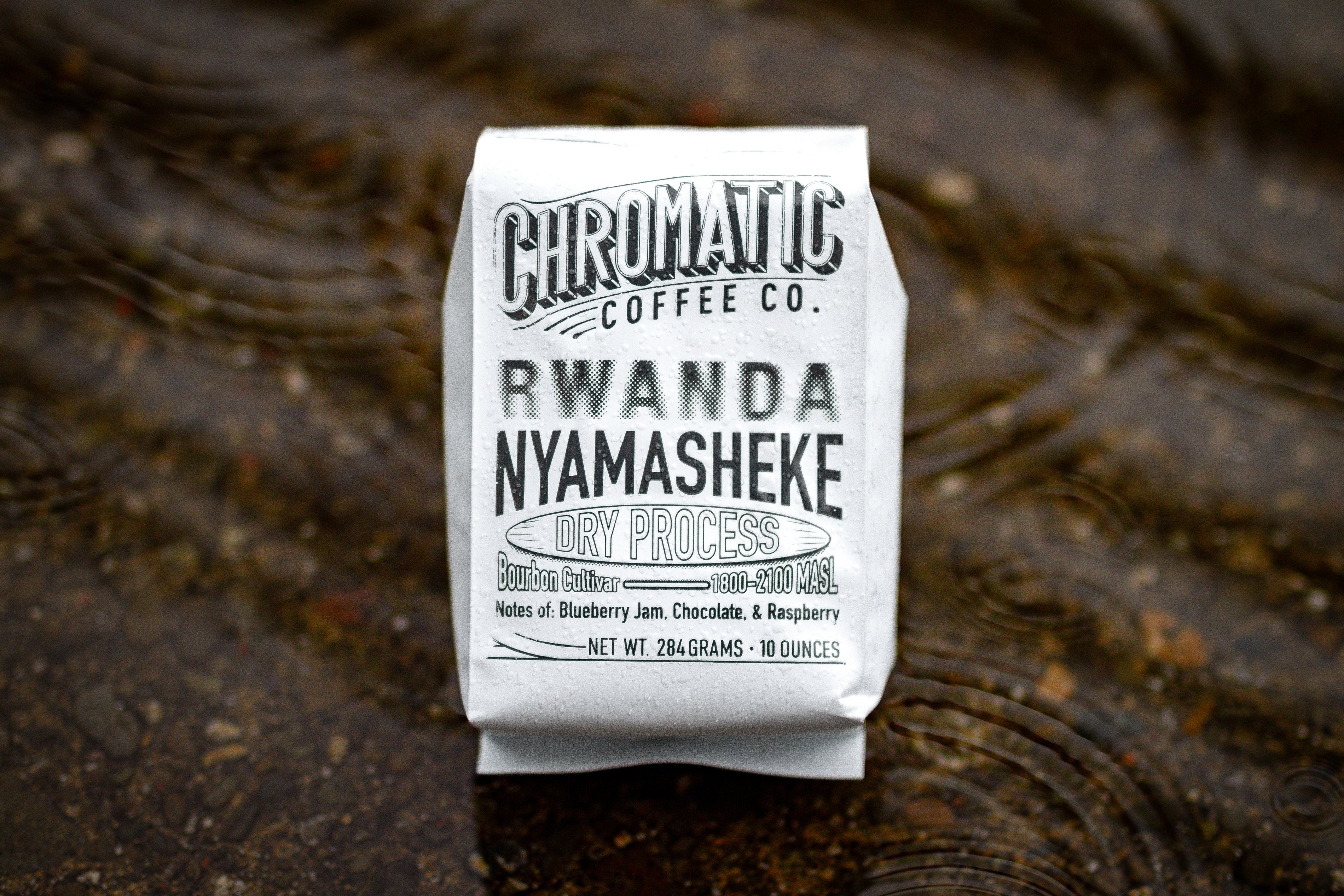 Photo of bag of Rwanda Nyamasheke Dry sitting on ripples of water.