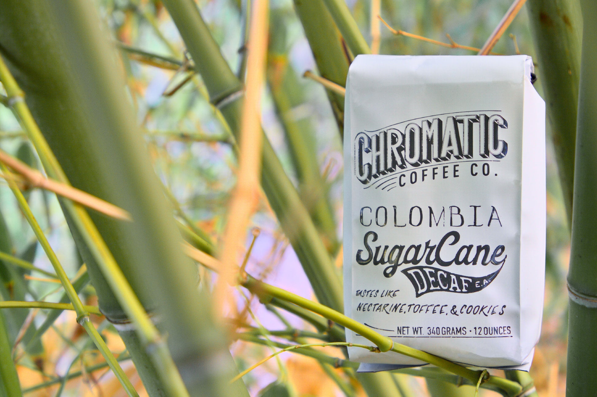 Sugarcane Decaf-Chromatic Coffee-Bag of Chromatic Coffee Colombia SugarCane Decaf among green bamboo stalks.